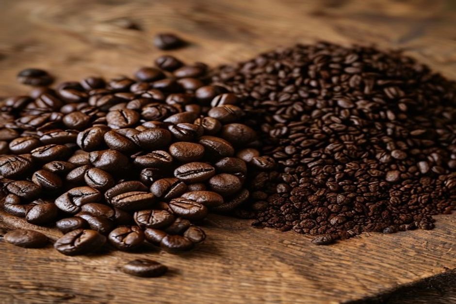 Granos de café enteros y café molido, dos montones uno al lado del otro